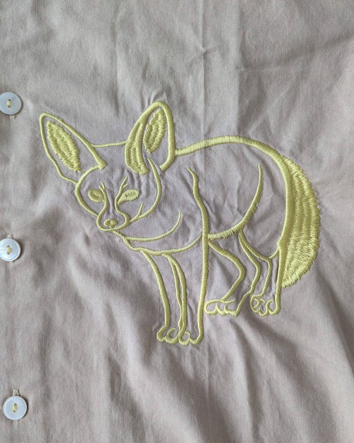 Embroidered fox design on a beige fabric background
