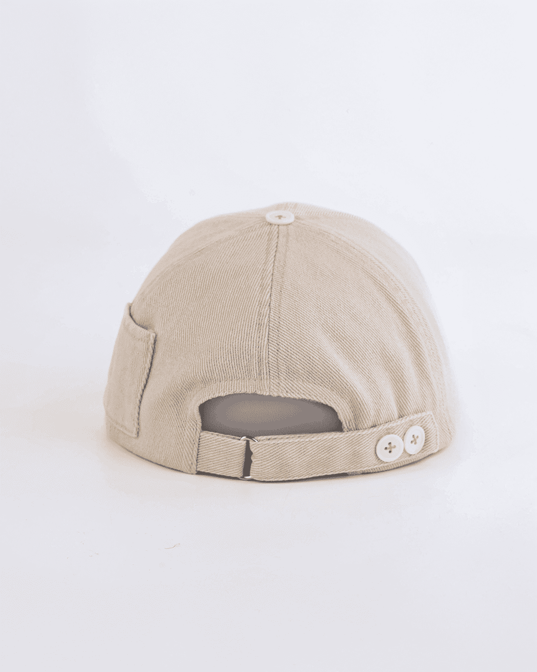 Beige cap with button details on a white background