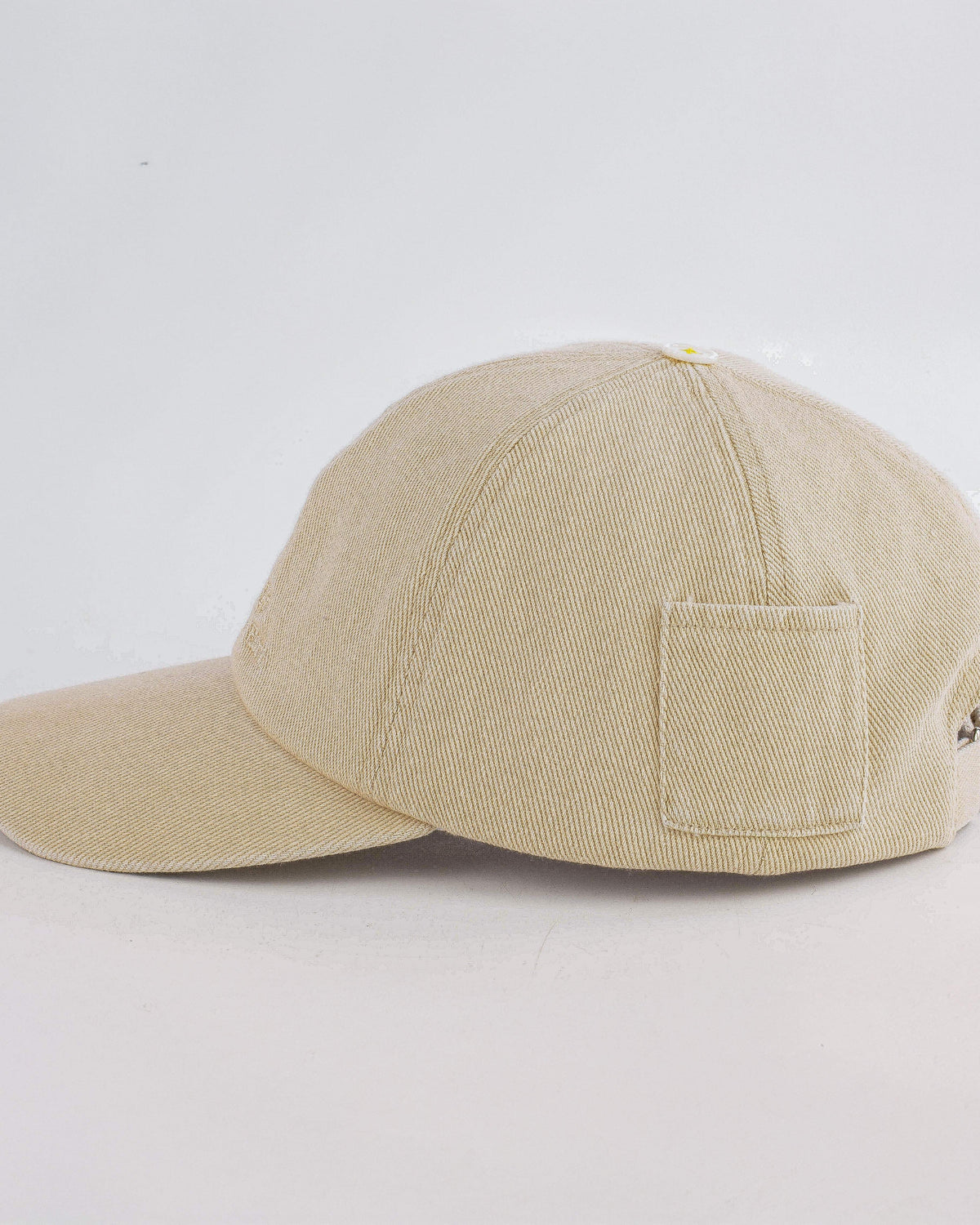Beige baseball cap with a pocket on a light gray background